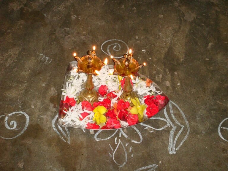 Oil wick lamps decked with flowers at a doorstep for Deepavali